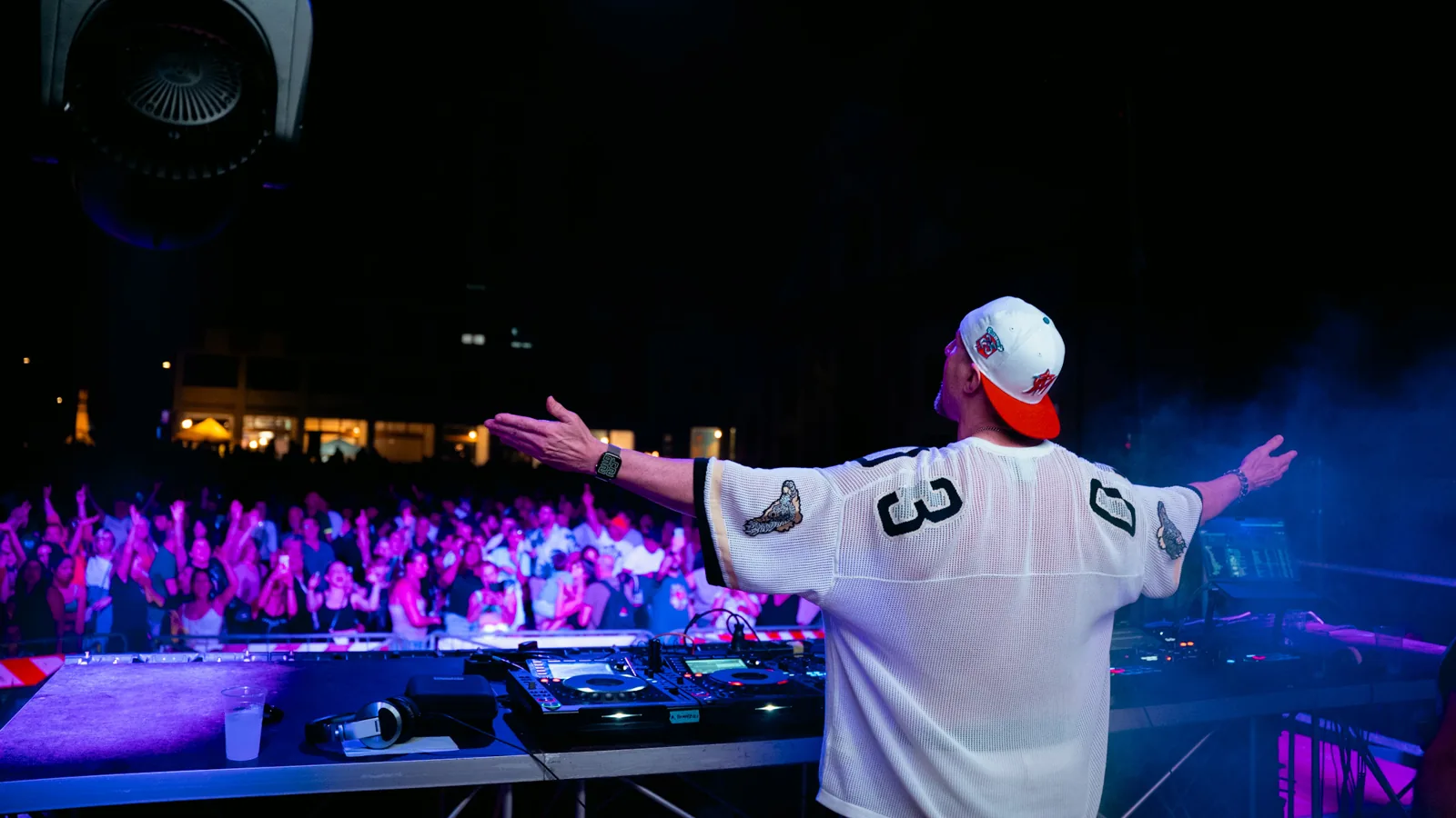 Artista visto da dietro alla console sul palco, davanti al pubblico