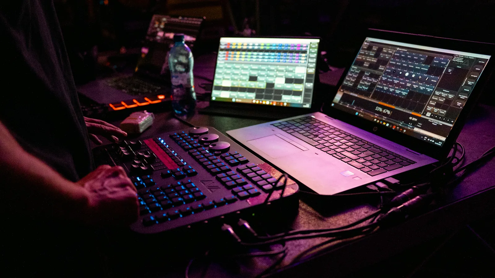Operatore a una console, con computer e schermi illuminati